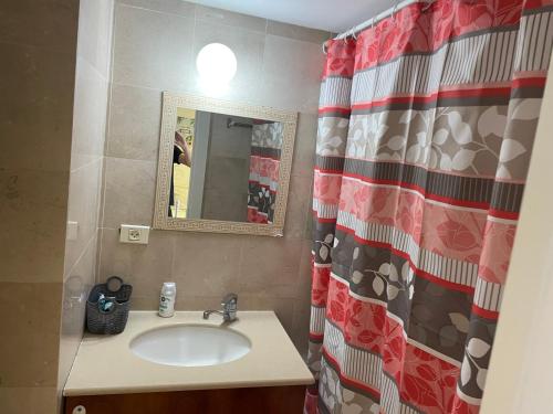 a bathroom with a sink and a shower curtain at מגדלי המרינה in Herzliyya B