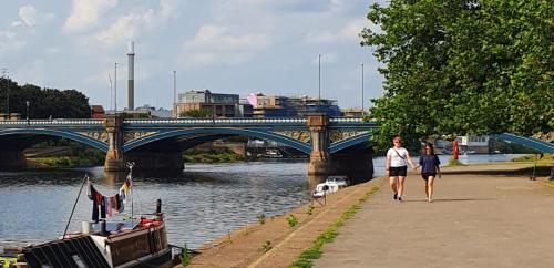 a man and woman walking down a sidewalk next to a bridge at Spacious 2 Bed Village Flat sleeps 4/6 in Nottingham