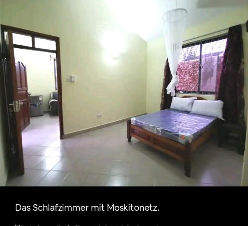 a room with a bed and a window and a mirror at Lisa in Mombasa