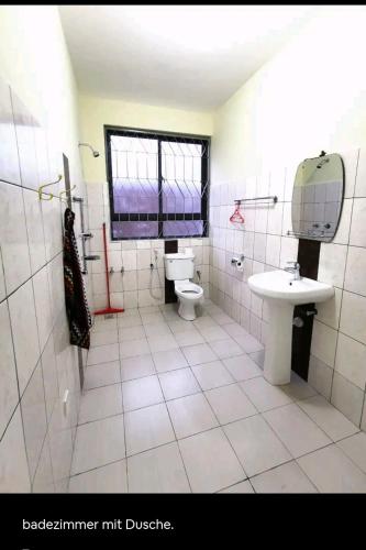 a bathroom with a toilet and a sink at Lisa in Mombasa