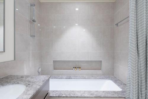 een badkamer met een bad en een wastafel bij Mystic - Forte Tower 2 in Dubai