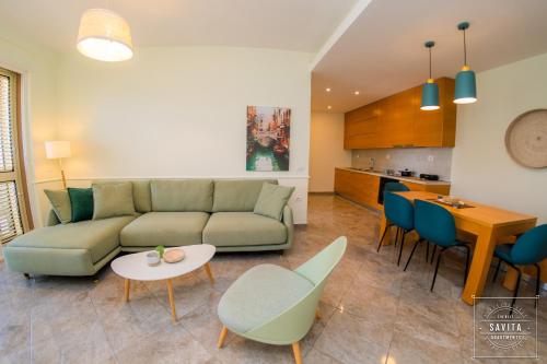 - un salon avec un canapé, une table et des chaises dans l'établissement Gjiri i Lalzit - Savita Apartments - Kompleksi Turistik Lura 3, à Mullini i Danit