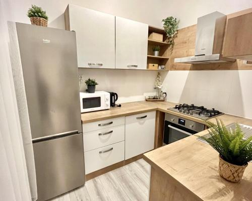 a kitchen with white cabinets and a stainless steel refrigerator at Apartment Robin - Old Town in Bratislava