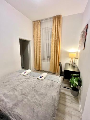 a bedroom with a bed and a desk and a window at Apartment Robin - Old Town in Bratislava