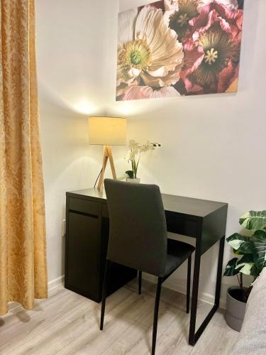 a black desk with a chair and a lamp at Apartment Robin - Old Town in Bratislava