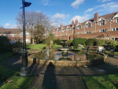 a fountain in the middle of a courtyard with a building at Single room in charming apartment with the terrace and the cat in Sandymount in Dublin