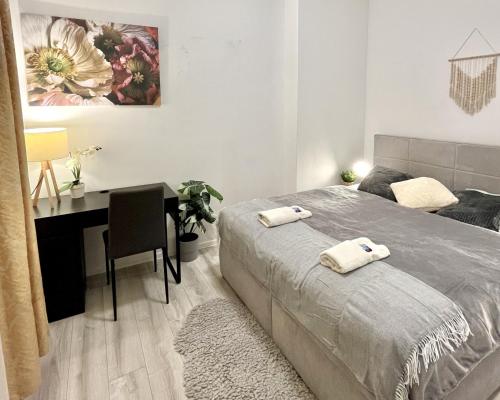 a bedroom with a bed and a desk with towels on it at Apartment Robin - Old Town in Bratislava