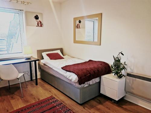 - une chambre avec un lit, un bureau et une chaise dans l'établissement Charming apartment with big terrace in Sandymount, à Dublin