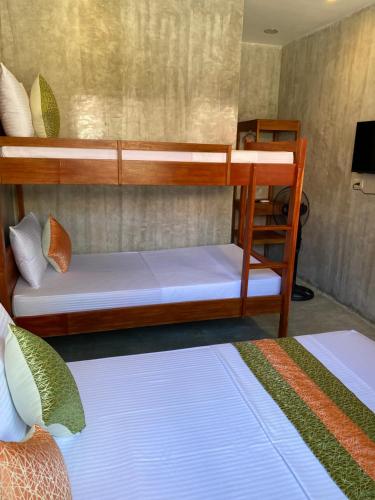 a bunk bed room with two beds and a television at RL Harbor Inn in El Nido