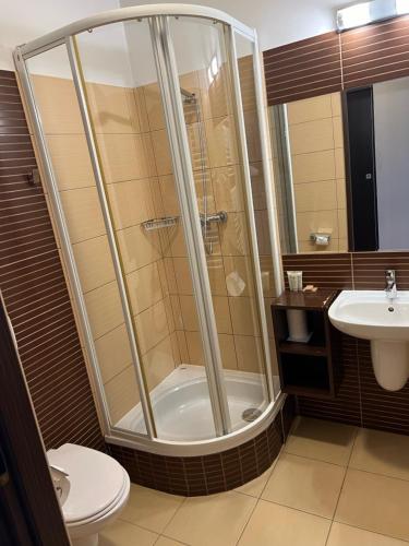 a bathroom with a shower and a toilet and a sink at Hotel Pik in Mikołów