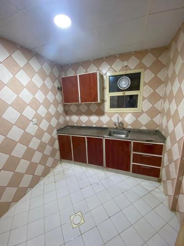 a tiled kitchen with a sink and a mirror at dafza metro Home in Dubai