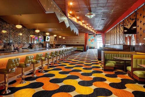 a bar with a yellow and black patterned floor at Hall House - Northeast Nashville Serene Rooftop Gem in Nashville
