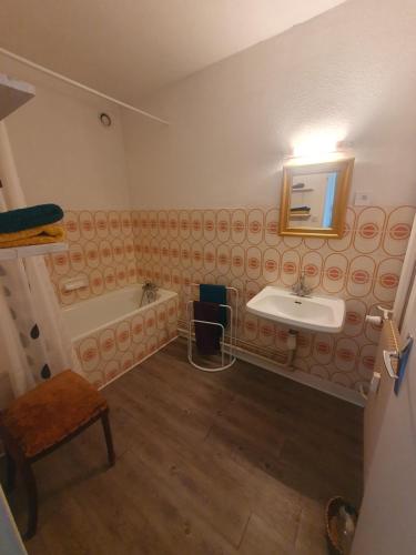 een badkamer met een wastafel en een bad bij L'atelier cosy in Beaune