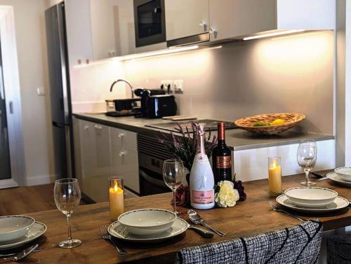 - une table en bois avec des bouteilles de vin et des verres dans l'établissement Appartement Penthouse Orihuela costa, à Orihuela Costa