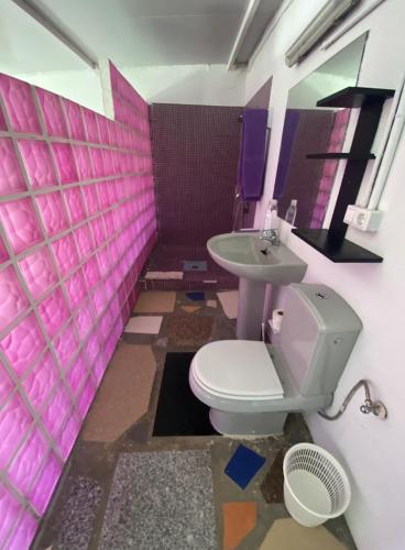 a pink bathroom with a toilet and a sink at Jacaranda in Cádiz