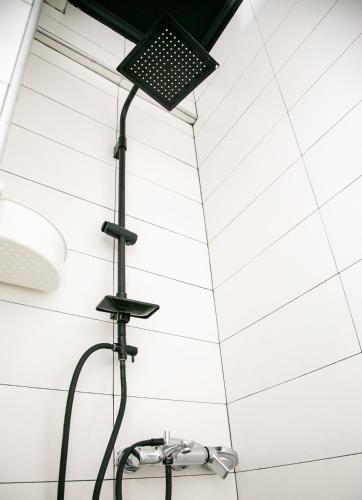 a shower in a bathroom with white tiles at Mikel Angelo hall in Serres