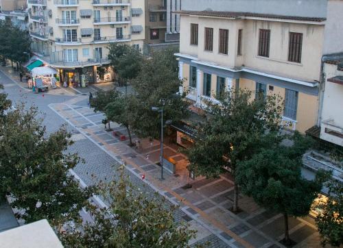 une vue sur une rue bordée d'arbres et de bâtiments dans l'établissement Mikel Angelo hall, à Serres