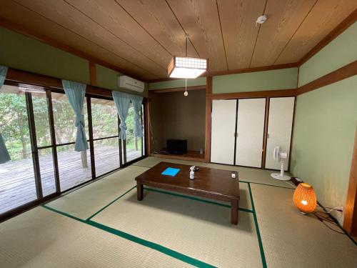 a living room with a table in the middle of a room at Yamamizuki in Shimanto