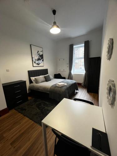 a bedroom with a bed and a table in it at Sauchiehall Street Apartment in Glasgow