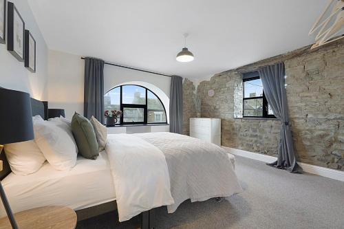 a bedroom with a large bed and a stone wall at Unicorn House Hot Tub Near Barnard Castle in Barnard Castle