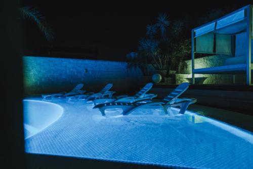 a group of chairs sitting in a pool at night at Villa Campito in El Puerto de Santa María