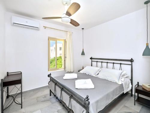 a bedroom with a bed and a ceiling fan at Villa Maria - Naoussa Boats Blue & Sandy Suite in Naousa
