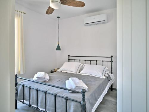 a bedroom with a metal bed with towels on it at Villa Maria - Naoussa Fishes Blue & Grey Suite in Naousa