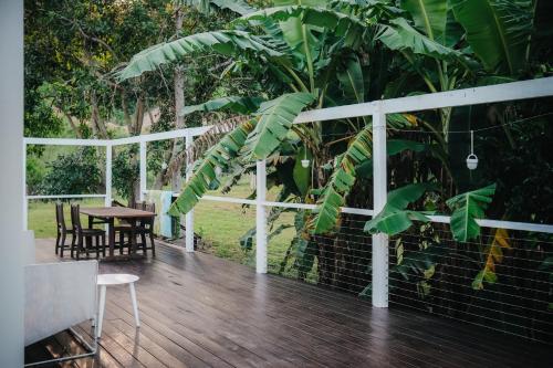 a wooden deck with a table and chairs and trees at Gheerulla Place in Gheerulla