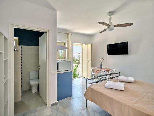 een slaapkamer met een bed en een badkamer met een toilet bij Villa Maria - Naoussa Squares Blue & Gold Suite in Naousa