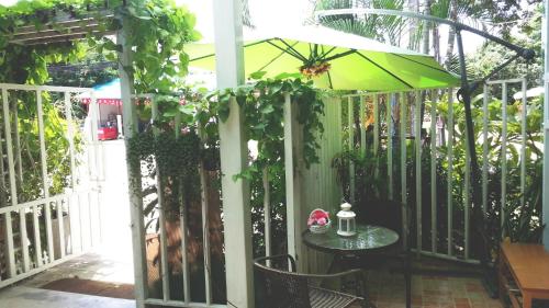 a patio with a table and an umbrella at Mo Do Ong in Ubon Ratchathani