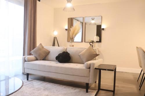 a living room with a white couch and a mirror at The Nest at Hemel Hempstead in Hemel Hempstead