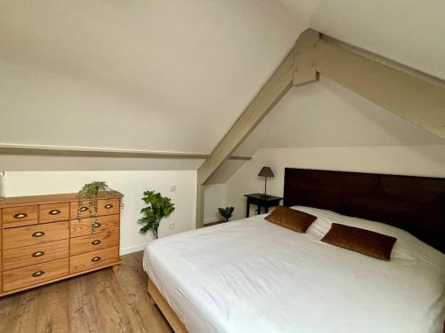 a bedroom with a white bed and a wooden dresser at Les Villas de Puys : Luxueuse Villa 7-9Pers in Dieppe