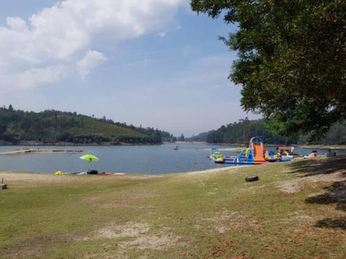 a beach with an umbrella next to a body of water at Country House - Hippie Garden in Vieira do Minho