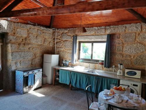 a kitchen with a sink and a stove top oven at Country House - Hippie Garden in Vieira do Minho