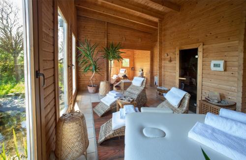 Casa de madera con porche y sala de estar. en Hotel & Restaurant Zum Kap Arkona en Putgarten