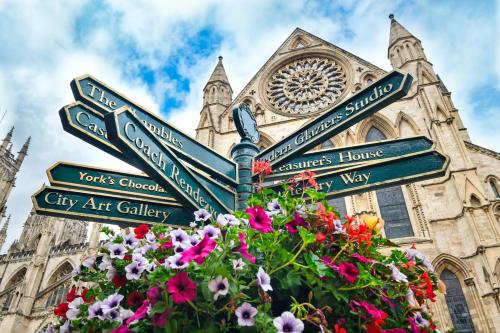 a street sign in front of a church with flowers at Bright & Beautiful Period Property - Pass the Keys in York