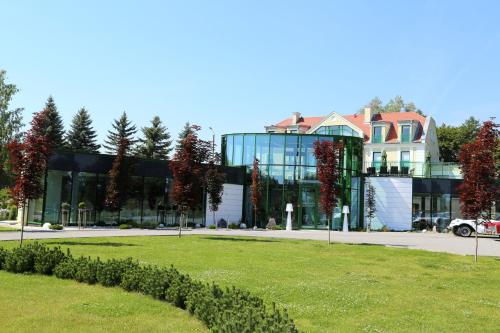 a large building with a grass field in front of it at Pokoje na Cyplu in Mrągowo