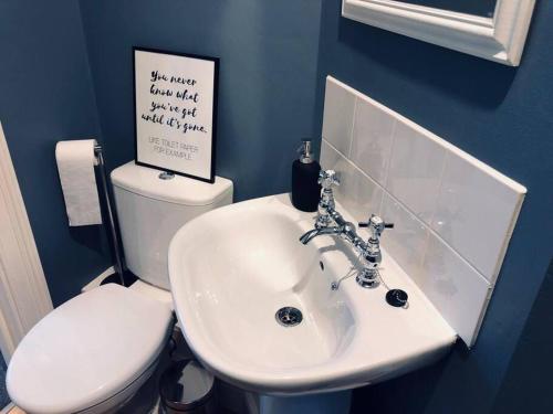 a bathroom with a white sink and a toilet at Central studio flat with parking permit in Bath