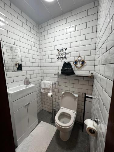 a white bathroom with a toilet and a sink at Sauchiehall Street Apartment in Glasgow