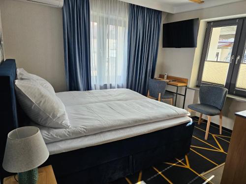 a hotel room with a bed and a desk and chairs at Richmount Apartamenty Karpacz in Karpacz