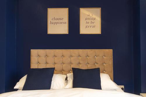 een slaapkamer met een bed met drie foto's aan de muur bij Station Apartment - 3 bedroom, five minutes from Harrogate Convention Centre in Harrogate