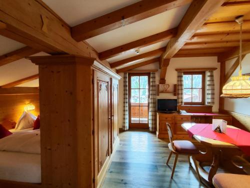 1 dormitorio con 1 cama, mesa y sillas en Hotel Gut Kramerhof, en Kirchdorf in Tirol
