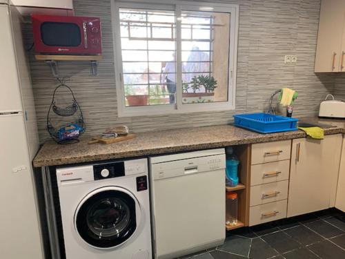 a kitchen with a washing machine and a microwave at Beautiful 3-Bed Town House with garden in Sax in Sax