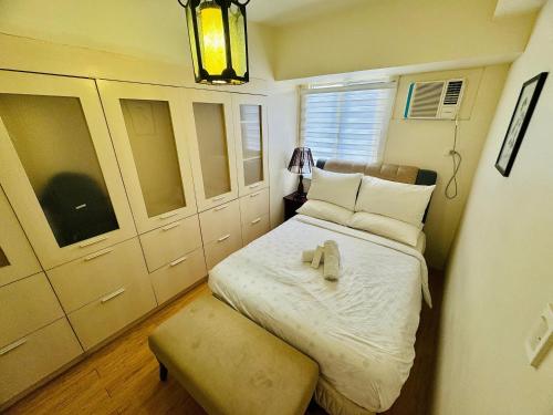 - une petite chambre avec un lit et un banc dans l'établissement One- Bedroom Avida Cebu Tower 1 IT Park, à Cebu