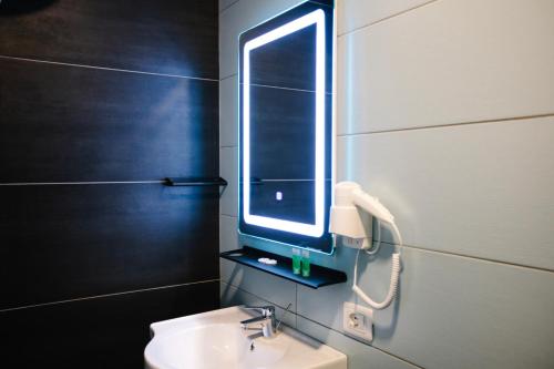 a bathroom with a sink and a mirror on the wall at Andor Luxury Hotel & Duplex in Durrës