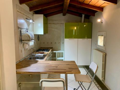 a kitchen with green cabinets and a wooden table at VILLA CAMPESTRE in Colombaro