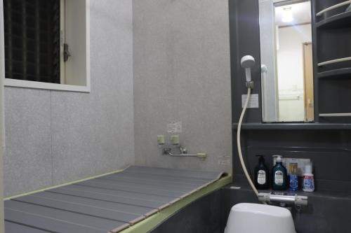 La salle de bains est pourvue d'un lavabo, de toilettes et d'un miroir. dans l'établissement Niji Homestay, à Osaka