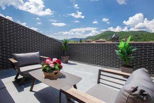 a patio with a table and chairs on a roof at Progrés Àtic in Ripoll
