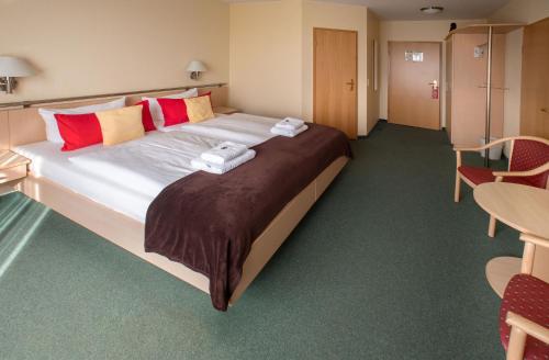 a hotel room with a large bed with towels on it at Hotel & Restaurant Zum Kap Arkona in Putgarten
