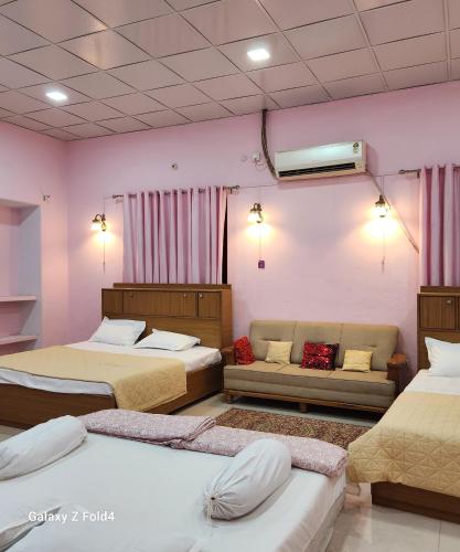 um quarto com três camas e um sofá em NICTBS em Prayagraj